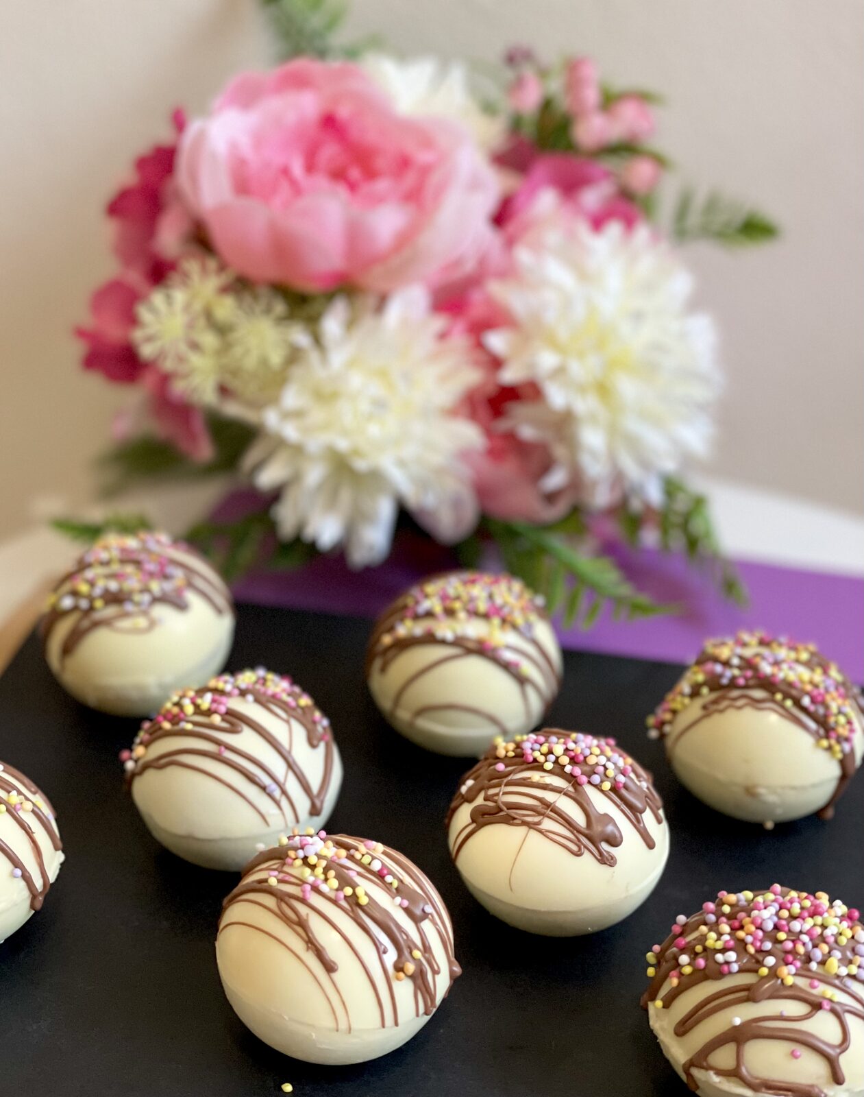 Handmade white chocolate bombs with pink peonies